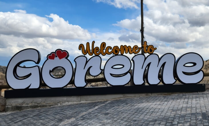Göreme’de yer alan “Welcome to Göreme” tabelası, beyaz harflerle yazılmış ve “o” harfinin üzerinde iki kalp simgesiyle süslenmiş.